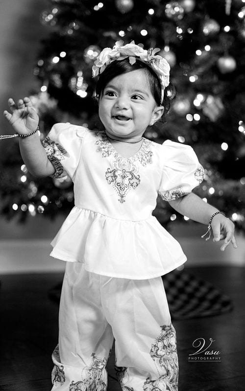 Black-and-white portrait of a smiling child in traditional clothing