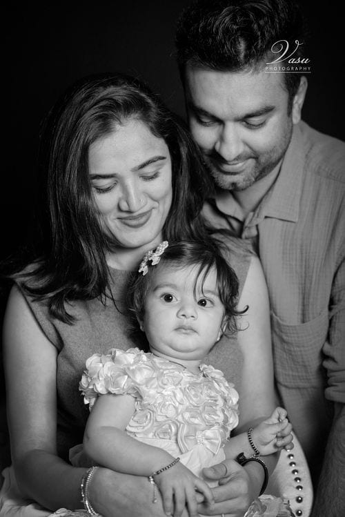 Black-and-white family portrait with parents and young child