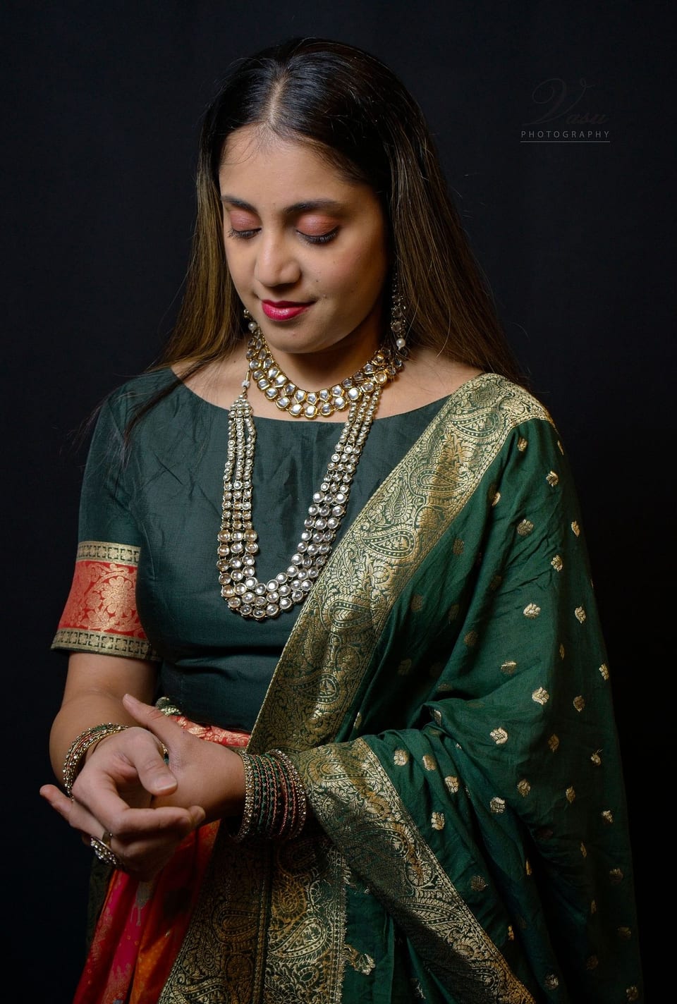 Studio portrait of a woman wearing a green sari and jewelry