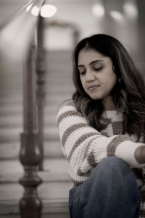 Thoughtful black-and-white portrait of a woman seated outdoors