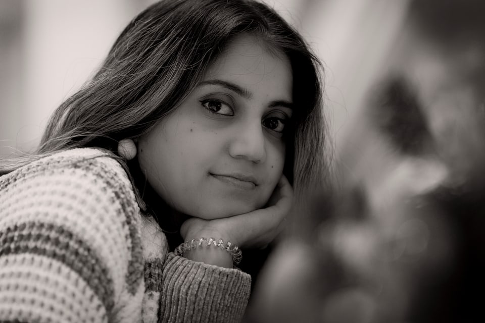 Close black-and-white portrait of a woman resting her chin on her hand