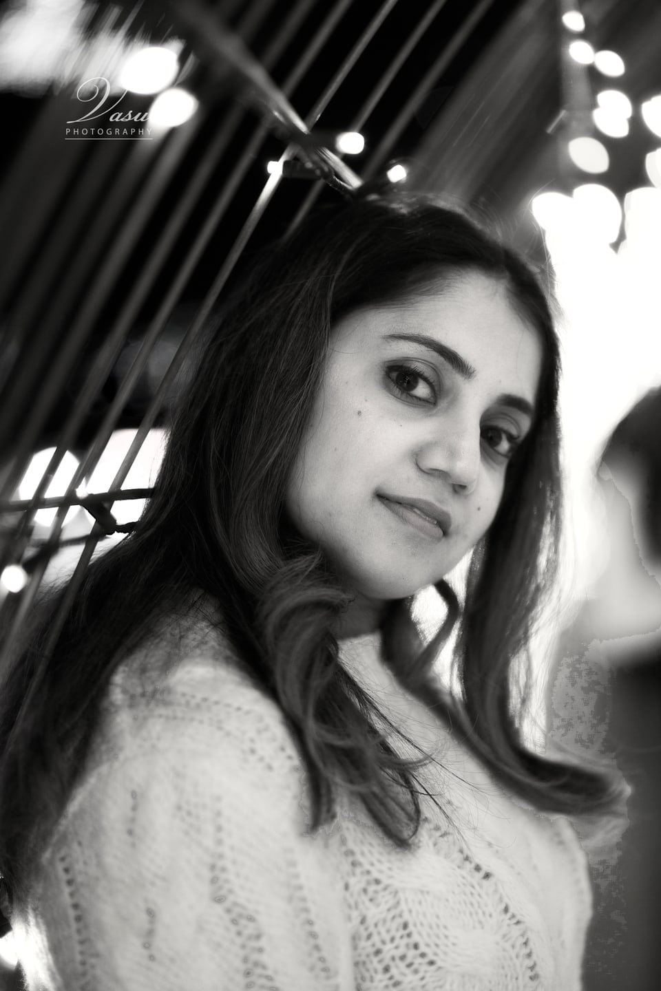 Black-and-white portrait of a woman framed by a reflective outdoor structure